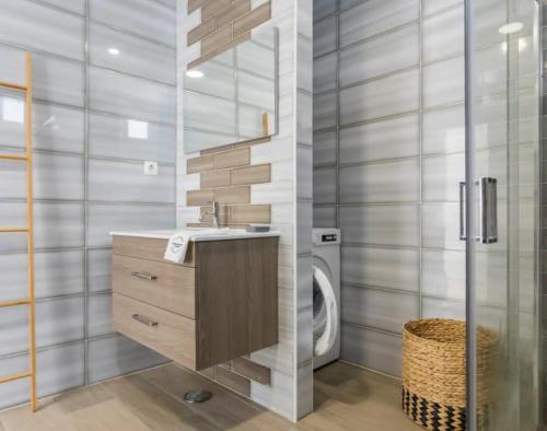 a bathroom with a sink and a washing machine at Casa da Madou in Setúbal