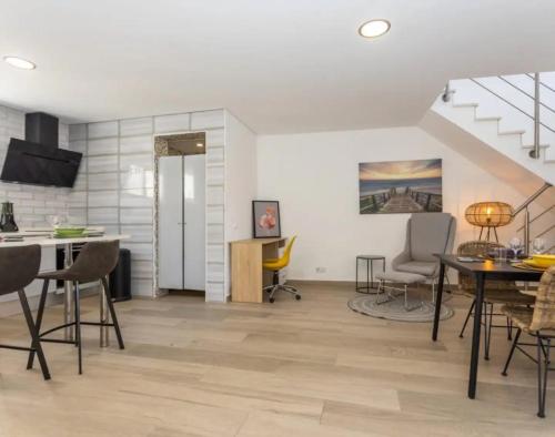 a living room with a table and chairs and a staircase at Casa da Madou in Setúbal