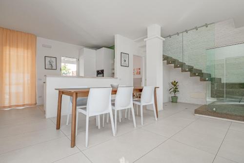 a kitchen and dining room with a table and chairs at Villa Cormorani 1 in Golfo Aranci