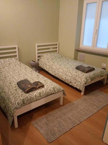 two beds in a room with two rugs at RHouse in Rho