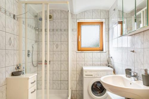 a bathroom with a washing machine and a sink at Ferienwohnung Schatzlmayr in Vilshofen an der Donau