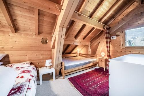 a bedroom in a log cabin with a bed and a window at Chalet 6p Classique-Les Ajoncs d'or in Verchaix
