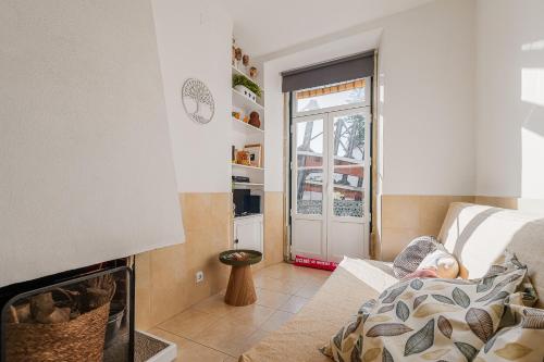 a person laying on a couch in a living room with a fireplace at Duplexdubocage in Setúbal