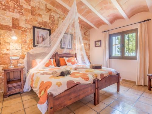 a bedroom with a bed with a mosquito net at Sa Barraca in Santanyi