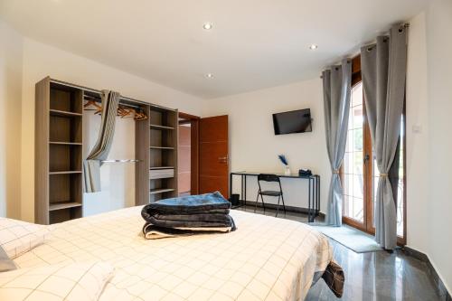 a bedroom with a bed and a desk in it at La Perle Bleue proche Strasbourg in Hoerdt