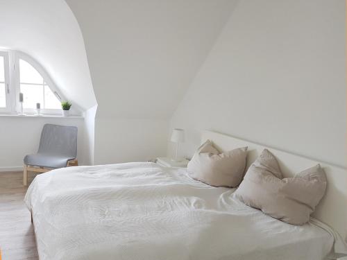 a white bed with white sheets and pillows at Haus Elve in Zierow