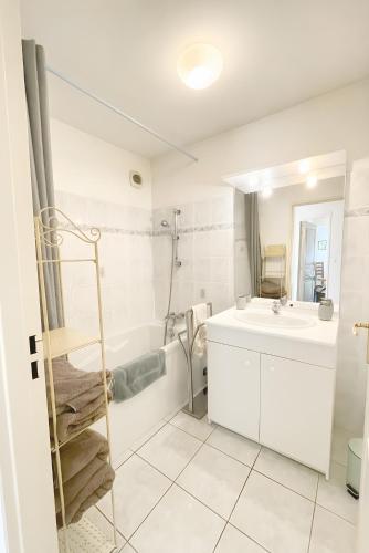 a white bathroom with a sink and a tub at Appartement De Standing Avignon in Avignon