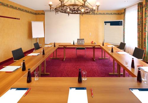 a large conference room with long tables and a whiteboard at Hotel Restaurant Paradeismühle in Klingenberg am Main
