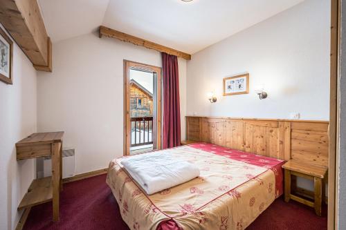 a bedroom with a bed and a window at Duplex confortable avec piscine in La Toussuire
