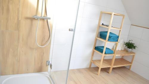 a bathroom with a shower and a shelf with towels at Ferienwohnung Wilhelmshof in Sinzig
