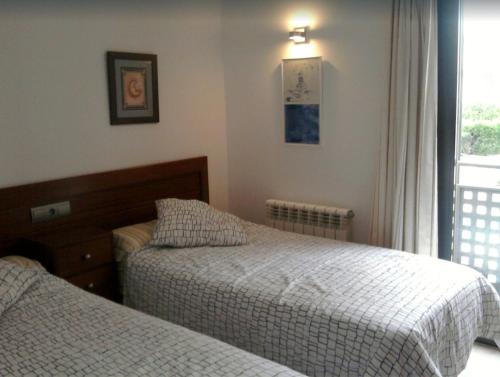 a bedroom with two beds and a window at Apartamento Llenaire in Pollença