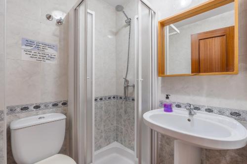 a bathroom with a toilet and a sink and a shower at Casa Roque in Monachil