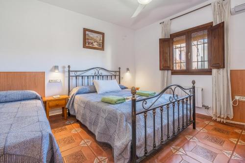 a bedroom with two beds and a window at Casa Roque in Monachil