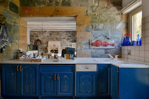 a kitchen with blue cabinets and a sink at Vitali River House Andros in Andros
