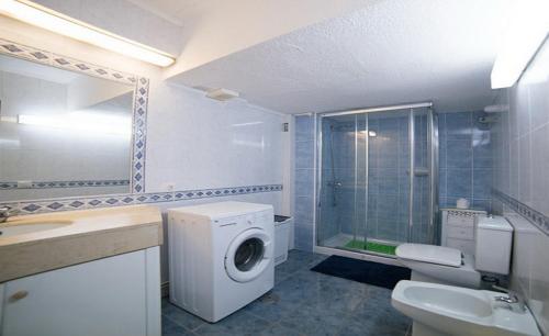 a bathroom with a washer and a sink and a washing machine at Magnific 3-bedroom beach Bungalow in Adeje