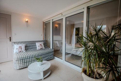 a living room with a couch and some potted plants at Chambre Armand in Louvigny