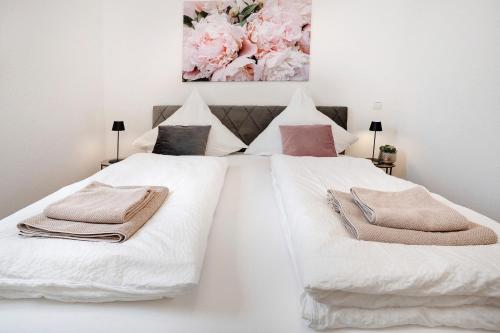 a bedroom with two white beds with towels on them at Klostergarten in Grünstadt
