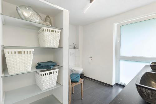 a bathroom with white shelves and a sink at Helgas Horizon in Rottweil