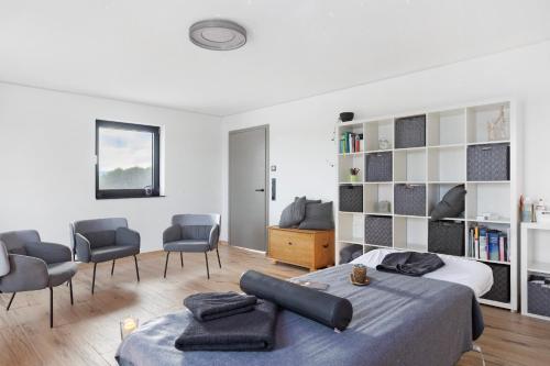 a bedroom with two beds and chairs and a book shelf at Helgas Horizon in Rottweil