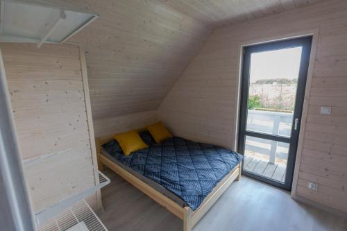 a small bedroom with a bed and a window at Domki u Bazyla in Sarbinowo