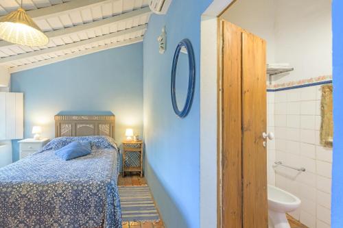 a blue bedroom with a bed and a bathroom at Sesmarias Dos Nobres in Azinheira dos Barros