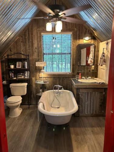 a bathroom with a tub and a toilet and a sink at Prickly Pear - Rustic Cabin in New Braunfels