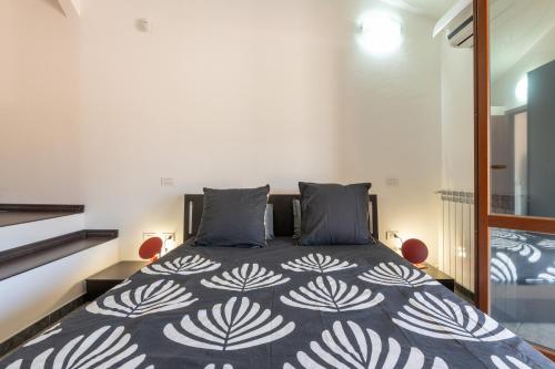 a bedroom with a bed with a black and white comforter at Casa Annabella in Sarroch