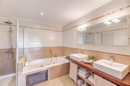 a bathroom with two sinks and a tub and a shower at Serra Fuster - Casa Tolleric in Llucmajor