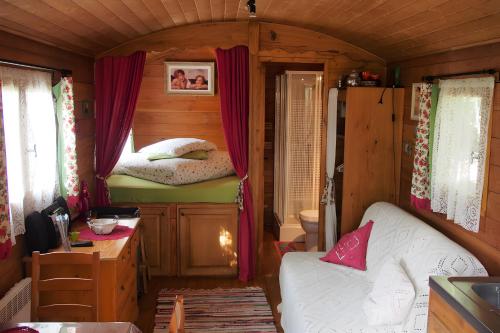 a small room with a bed and a couch in a tiny house at Roulotte De Cabrières in Compeyre