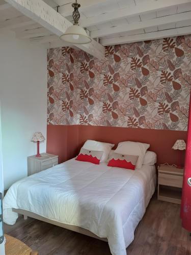 a bedroom with a white bed with a red wall at Maison Typique De Montagne in Ercé