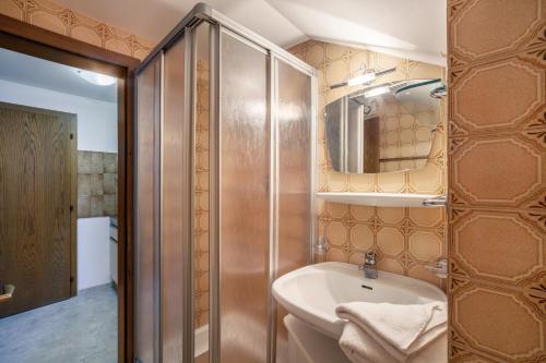a bathroom with a sink and a mirror at Rieglhof Apartment Hennennest in Curon Venosta