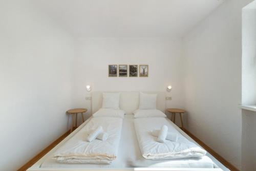 a white bed in a room with two pillows at Premium App Hofer Monika in Villabassa