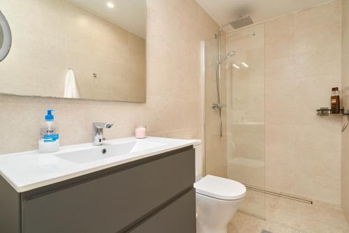 a bathroom with a toilet and a sink and a shower at Exclusive Getaway – Ocean View in Torrox Costa