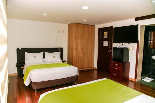 a bedroom with a bed and a flat screen tv at Casa Lavim in Bogotá
