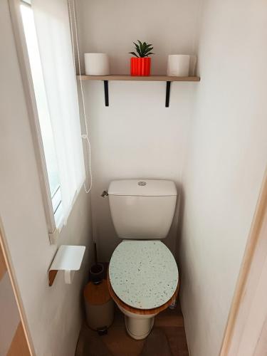 a small bathroom with a toilet and a window at Escale en Provence in Carqueiranne