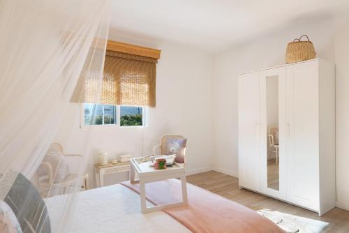 a white living room with a table and a window at Villa Tino- Casa D in Los Llanos de Aridane