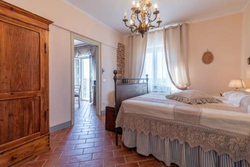 a bedroom with a bed and a chandelier at Casa del Nonno Bingheri in Cortona