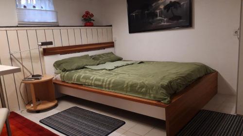 a bedroom with a bed with a green comforter at Gästezimmer Jülich mit Küche in Weil am Rhein