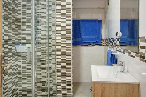 a bathroom with a sink and a glass shower at Arinaga Home in Arinaga