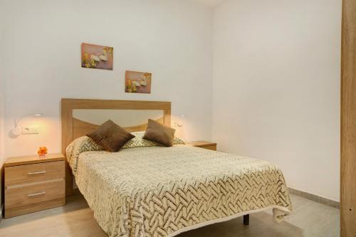 a bedroom with a bed with a wooden headboard and a mirror at Arinaga Home in Arinaga