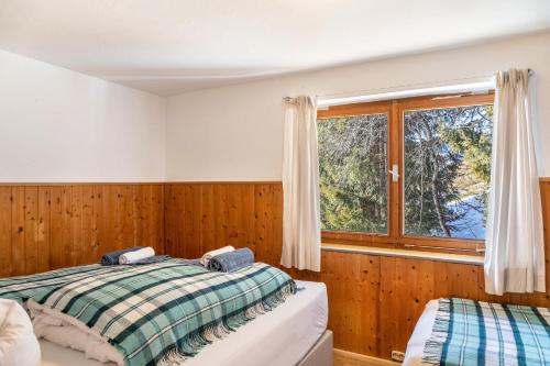 a bedroom with two beds and a window at Sonnenhütte Wildschönau Obergeschoß in Grafenweg