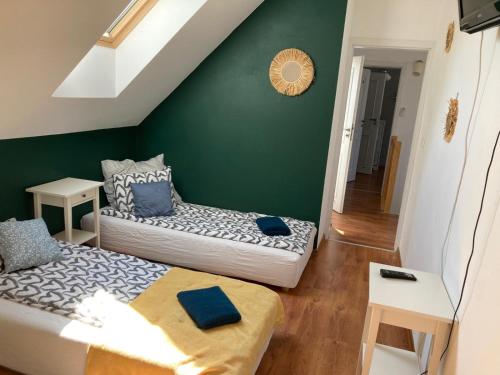 two beds in a room with a green wall at Mazurska Oaza in Pisz