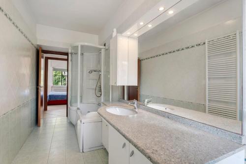 a white bathroom with a sink and a toilet at Unique Lake View In Green Park in Nebbiuno