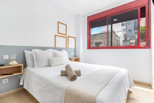a bedroom with a large white bed with a window at Casa Almi Las Palmas in Las Palmas de Gran Canaria