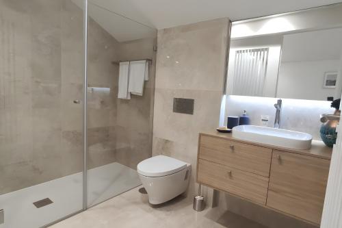a bathroom with a toilet and a sink and a shower at Douro Barcos House Local in Barcos