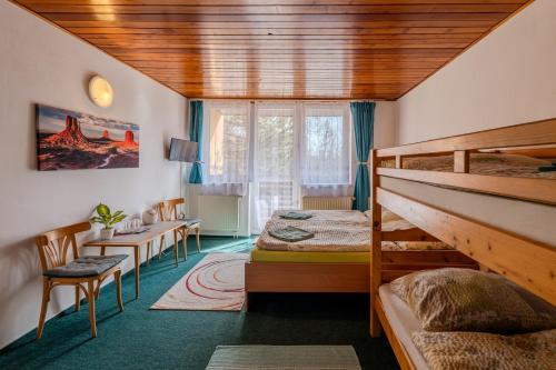 a bedroom with two bunk beds and a desk at Penzion Tesák-ČERŇAVA in Chvalčov