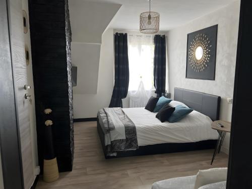 a bedroom with a bed with blue pillows and a window at Gite des Coteaux Pmr in Sainte-Maure-de-Touraine