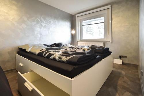 ein Bett in einem Zimmer mit Fenster in der Unterkunft Apartment Grey Stuttgart in Stuttgart