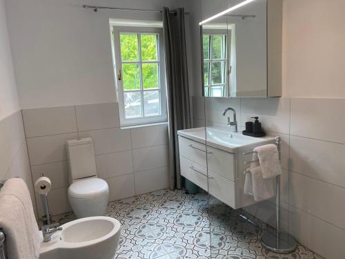a white bathroom with a sink and a toilet at Weingut Kleinmonte in Leutschach