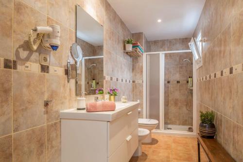 a bathroom with a white sink and a toilet at Casa Yerida in El Cotillo